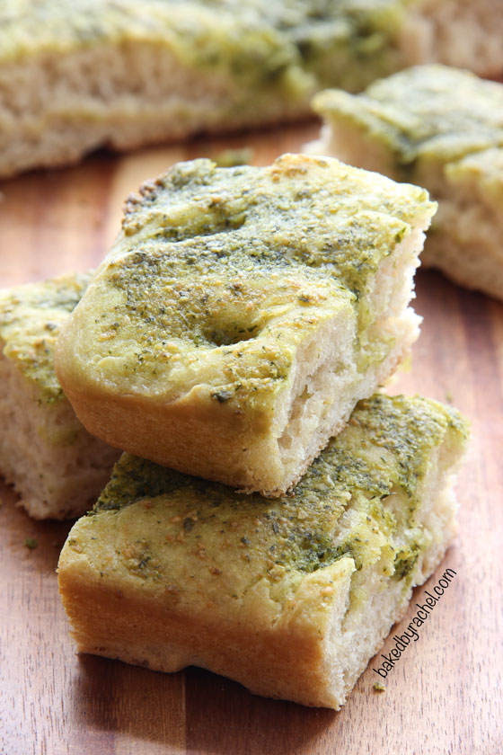 Homemade focaccia bread topped off with a flavorful basil-pesto sauce. Recipe from @bakedbyrachel