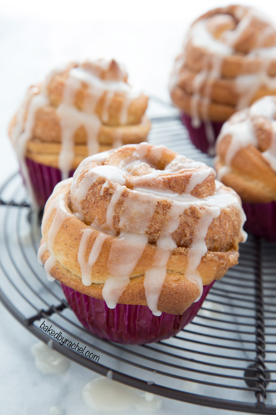 Tender cinnamon roll muffins with vanilla glaze recipe from @bakedbyrachel. A perfect addition to breakfast or brunch!
