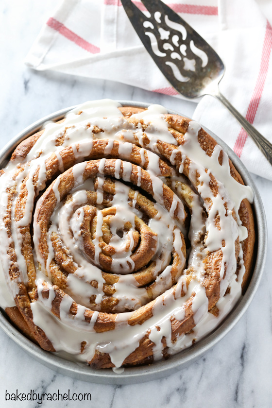 Giant fluffy homemade cinnamon roll cake with a sweet vanilla glaze. Recipe from @bakedbyrachel