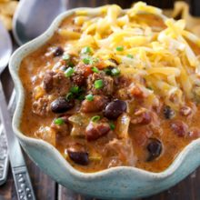 Hearty slow cooker cheesy beef and bean nacho chili recipe from @bakedbyrachel