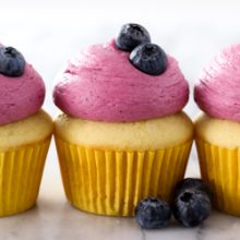 Moist homemade lemon cupcakes with fresh lemon curd filling and blueberry buttercream frosting recipe from @bakedbyrachel A fun treat for any spring or summer occasion!